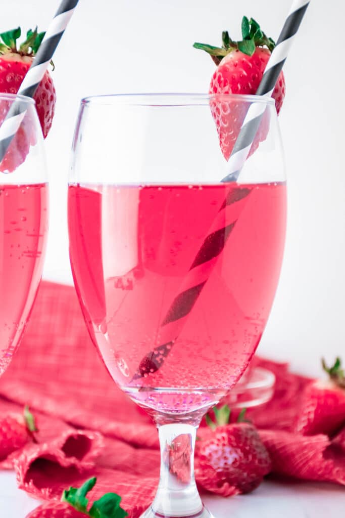 Cupid's Cocktail in a wine glass with a strawberry on the rim