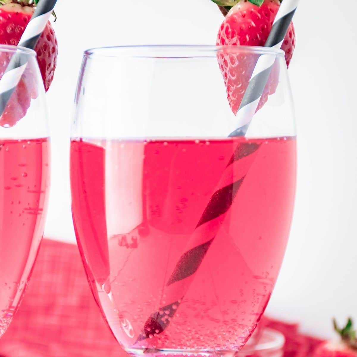 Cupid's Cocktail in a wine glass with a strawberry on the rim