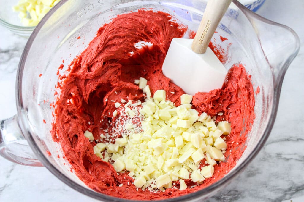 cream cheese, red velvet cake mix and chopped white chocolate in a glass mixing bowl