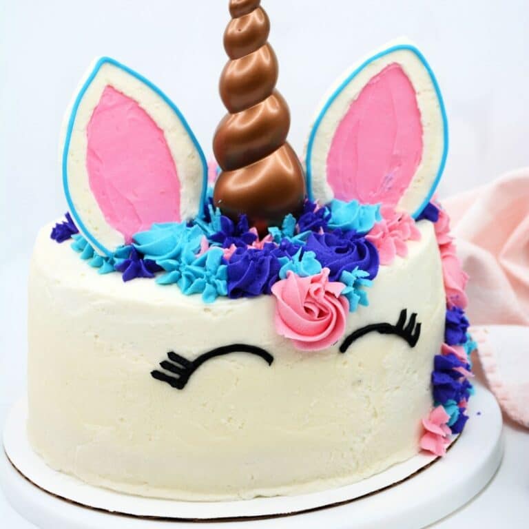 close up of the whole unicorn cake on a white cake plate