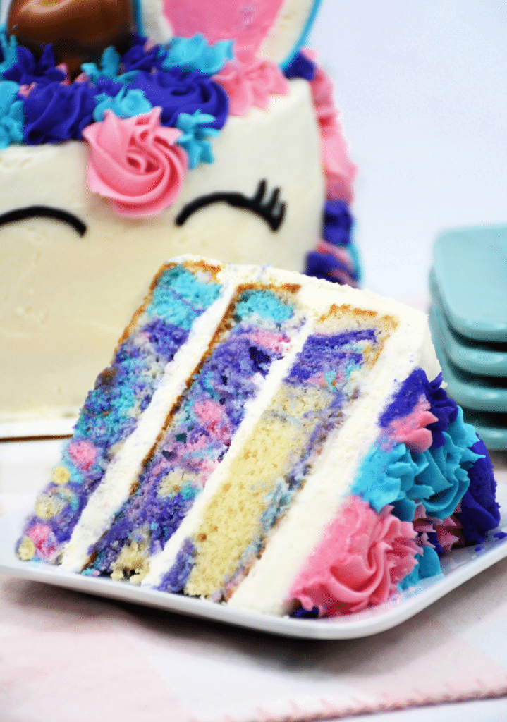 close up of a slice of unicorn cake on a square white plate