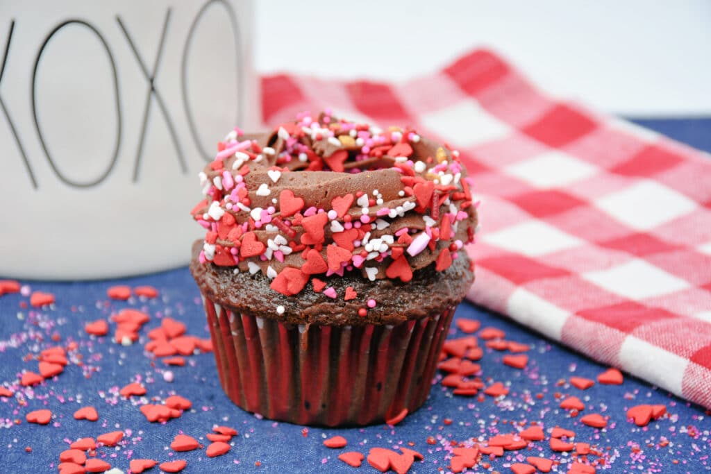 chocolate cupcake topped with chocolate frosting and valentine's sprinkles