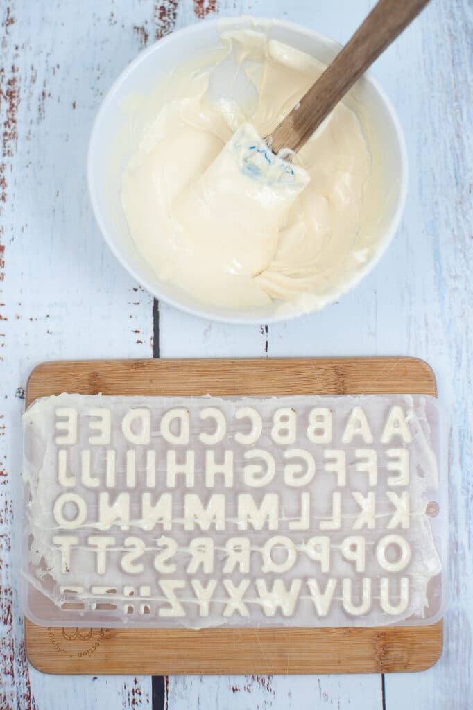 white chocolate being spread into a letter mold
