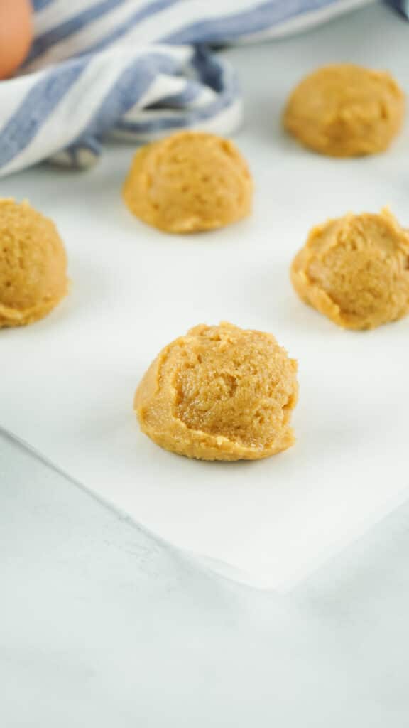 peanut butter cookie dough on piece of parchment paper on a white background