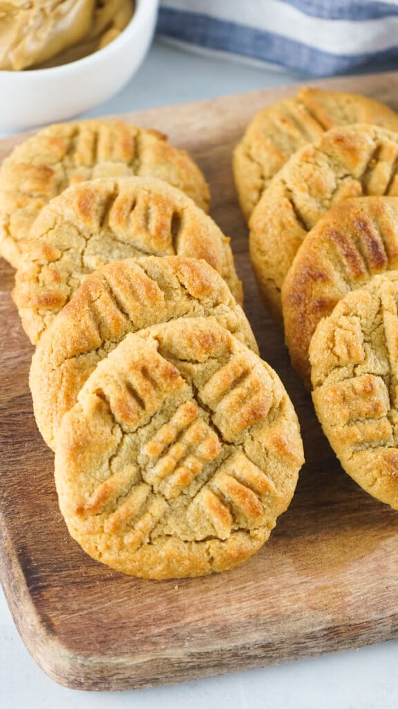 vertical off center image of Air Fryer Peanut Butter Cookies on a wooden cutting board