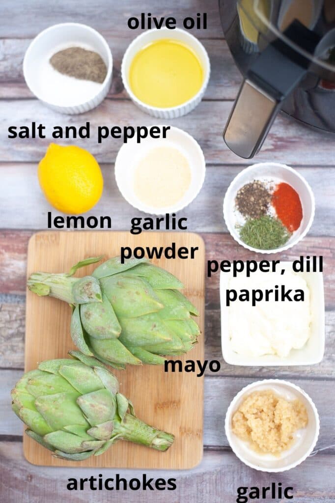 ingredients for air fryer artichokes on a wooden background labelled with text