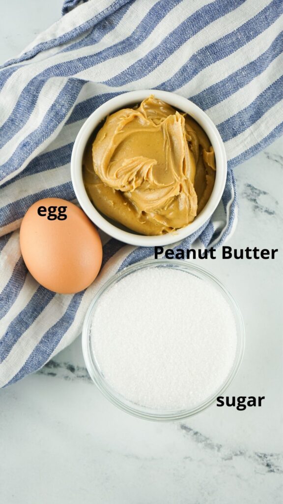 ingredients for air fryer peanut butter cookies on a marble counter labelled with text