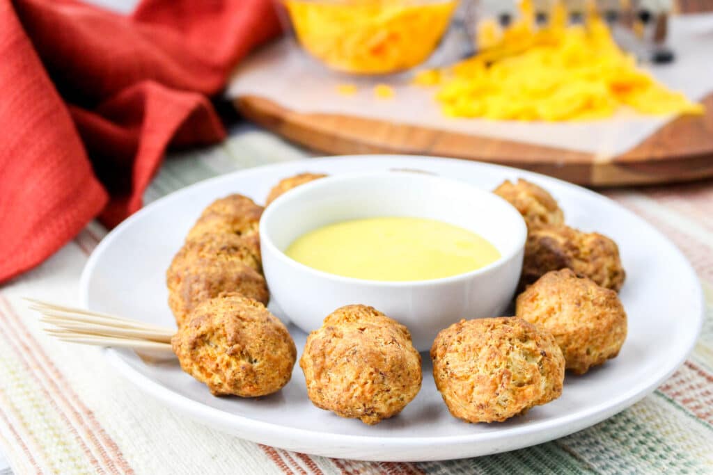 plate of air fryer sausage balls with a small bowl of honey mustard in the middle