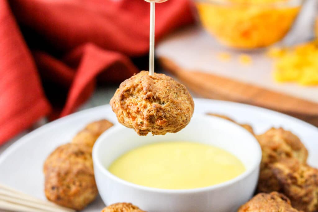 air fryer sausage ball over a bowl of honey mustard dipping sauce