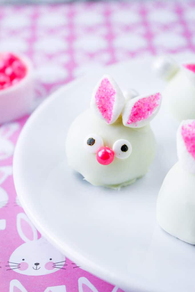 Bunny Oreo Balls on a white plate with a purple and white tablecloth