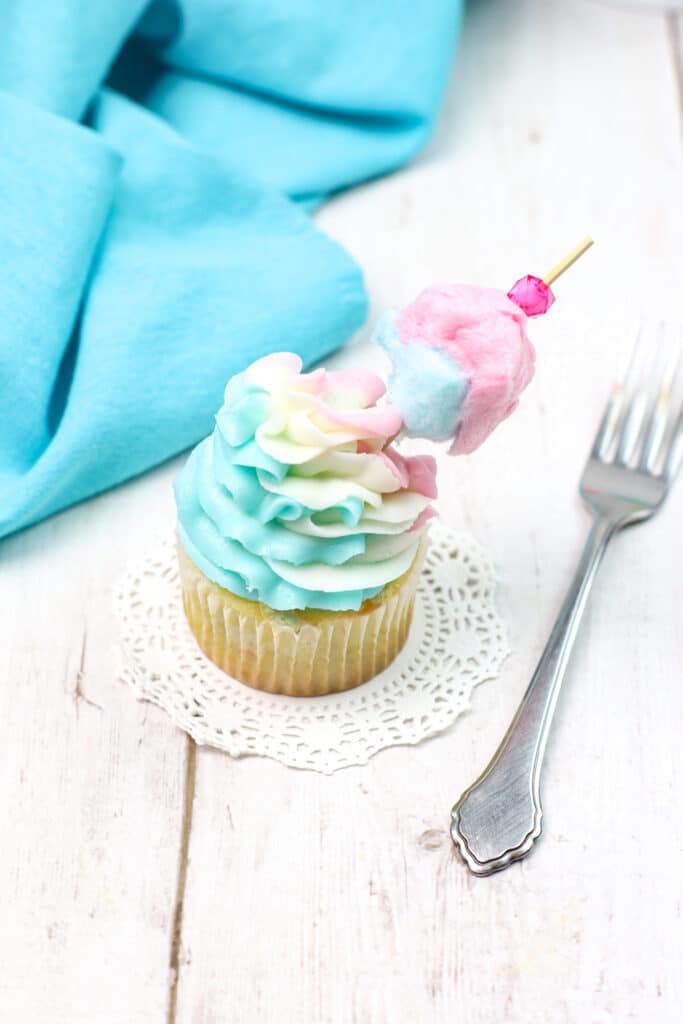 Cotton Candy Cupcake on a white lace with a sliver fork