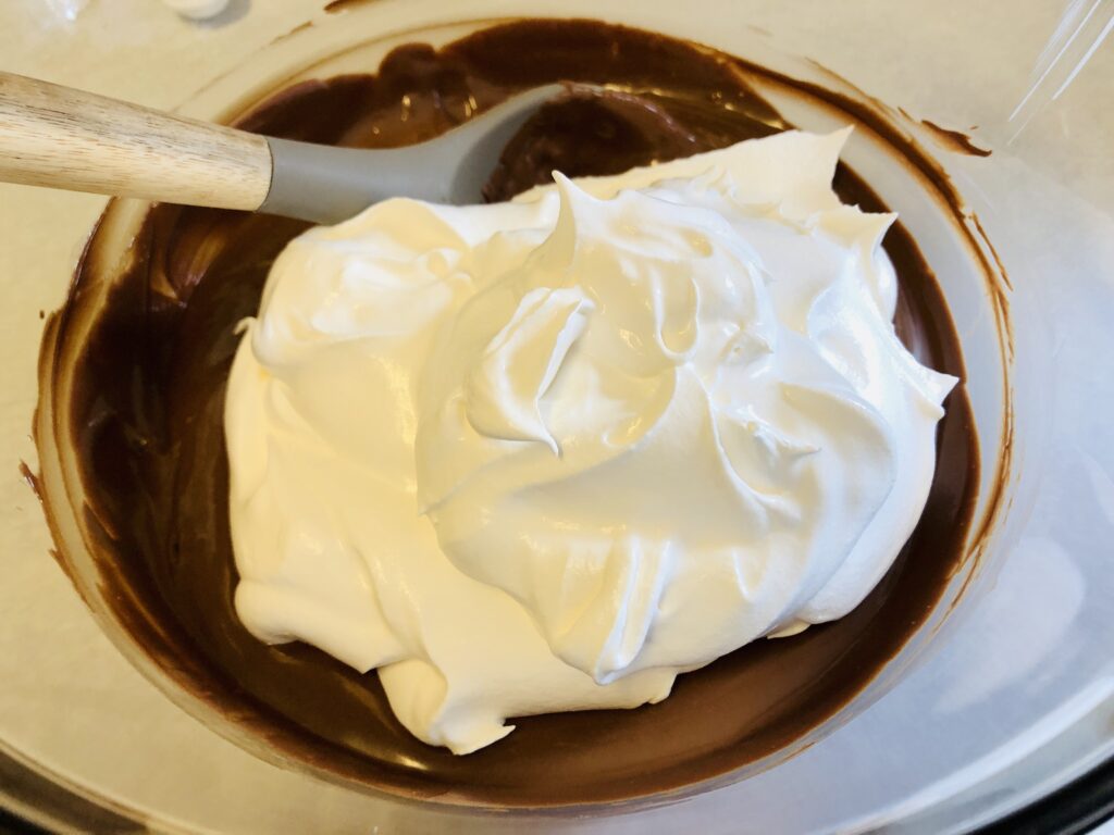 semi sweet chocolate chips and cool whip in a glass mixing bowl