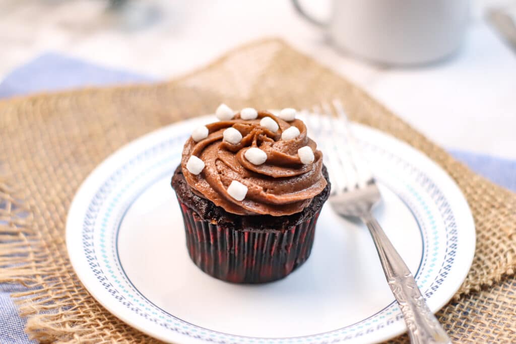 single hot cocoa cupcake on a white plate with a sliver fork
