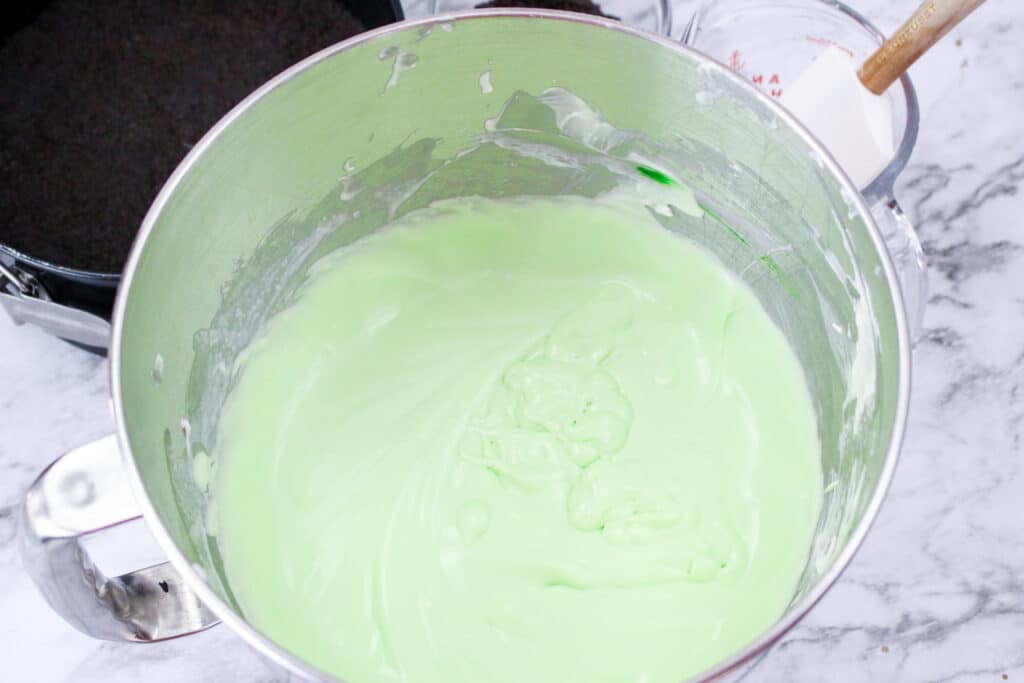 mint cheesecake batter in a metal mixing bowl