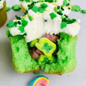 close up of the inside of a lucky charms cupcake broken open on a white background