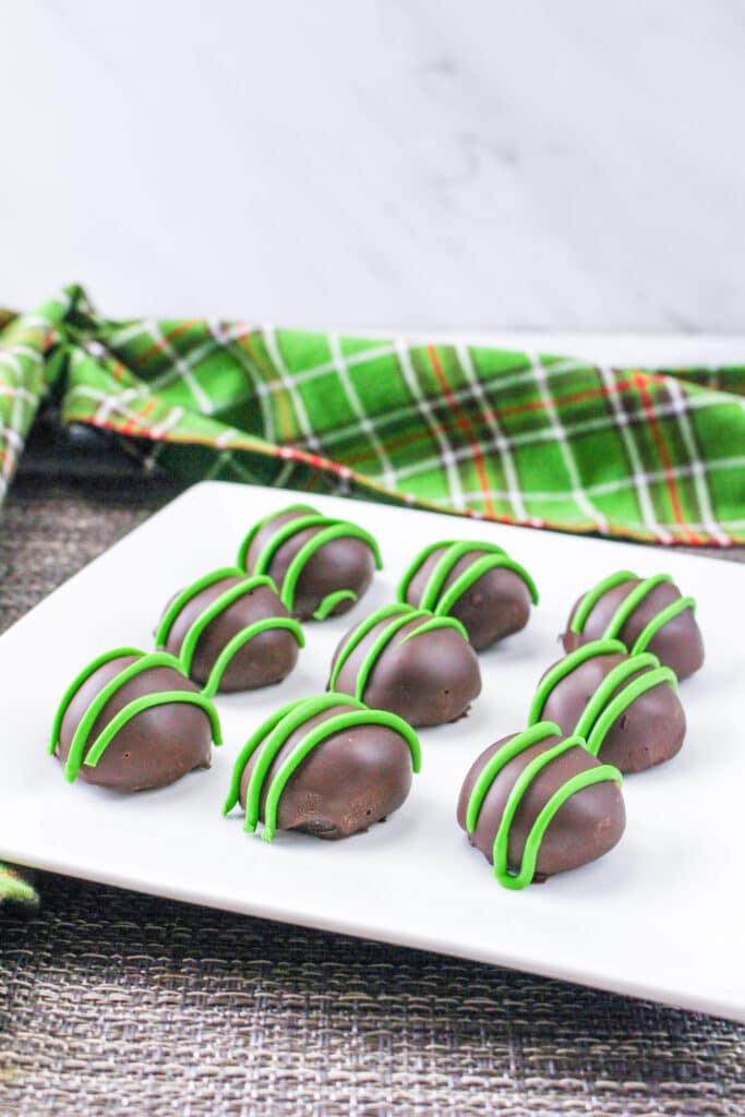 vertical image of a plate of mint oreo balls with a green and orange napkin in the background