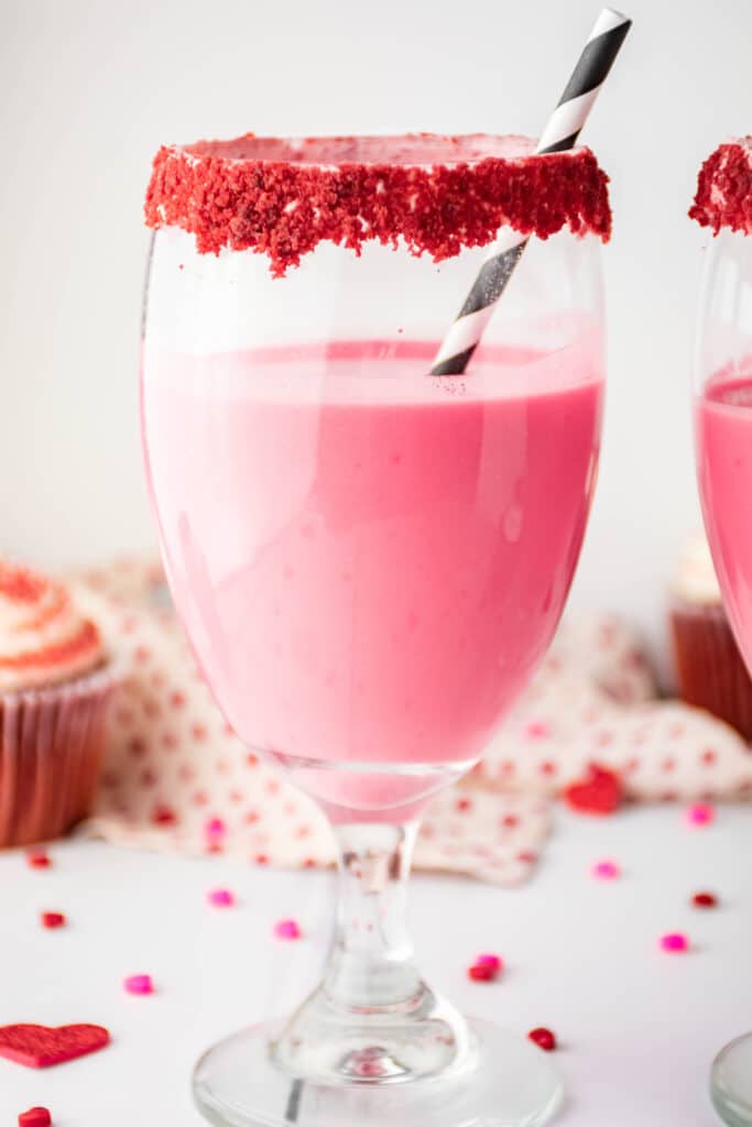 Red Velvet Cocktail in a glass with crushed red velvet around the rim