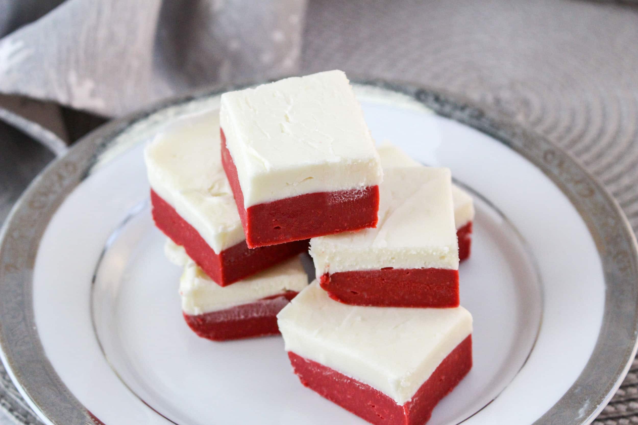 birds eye image of a red velvet fudge on a white plate with a sliver runner underneath it