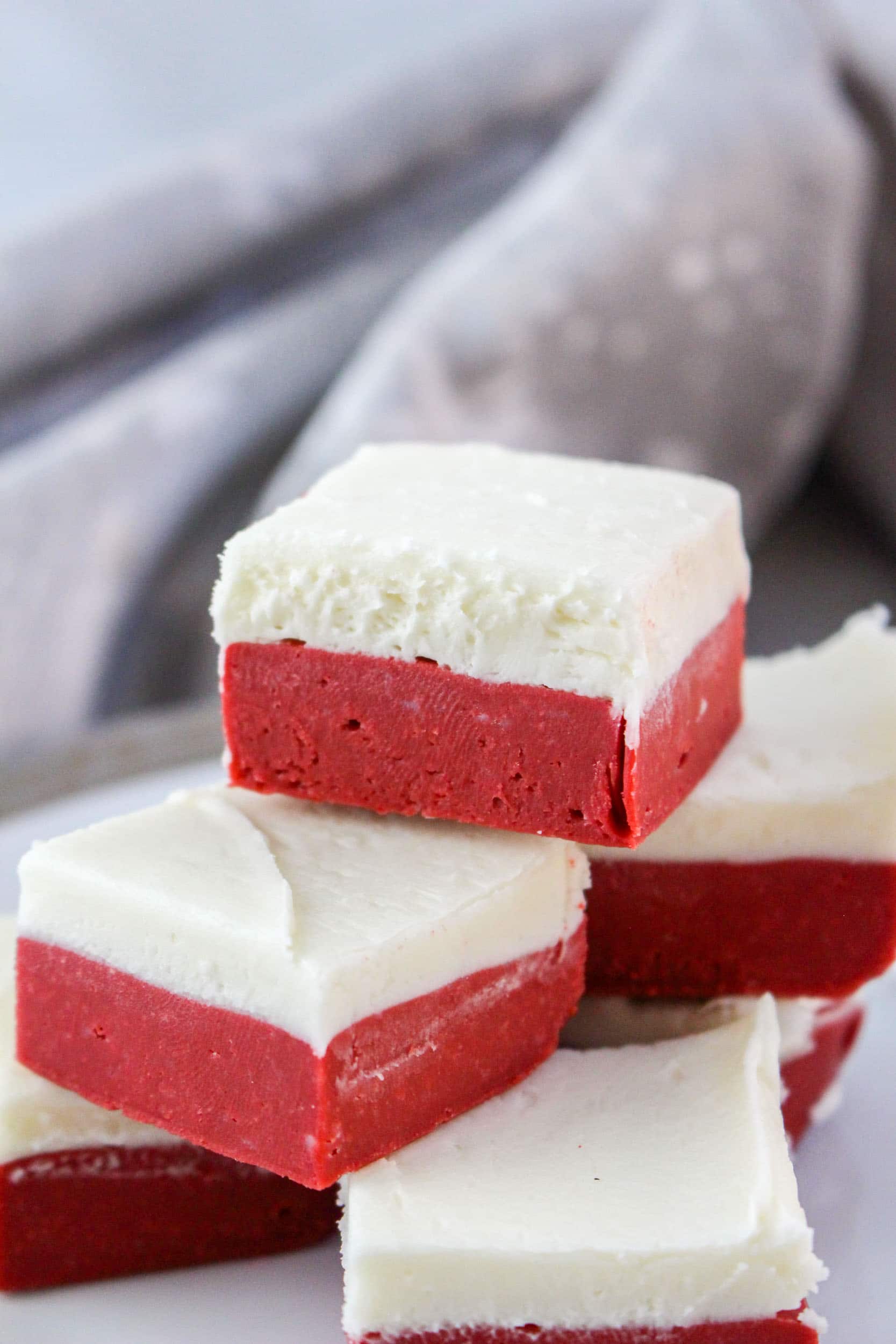 six red velvet fudge squares stacked on a white plate