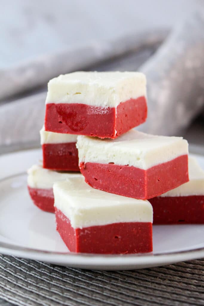 off center image of red velvet fudge stacked on a white plate