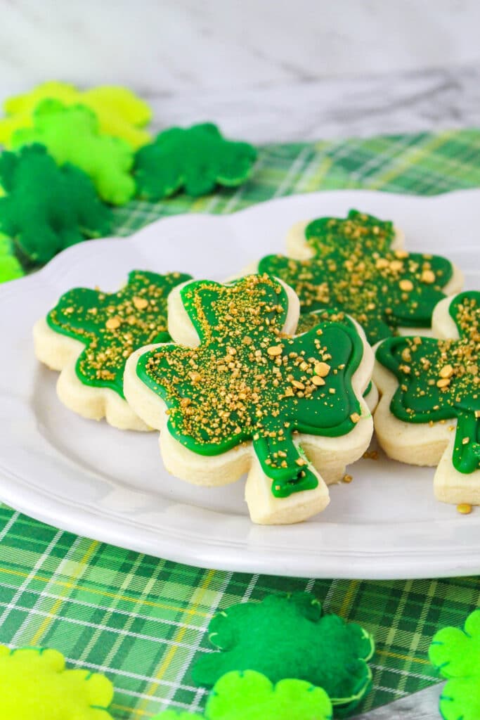 close up side view of st. patrick's day sugar cookies on a white plate
