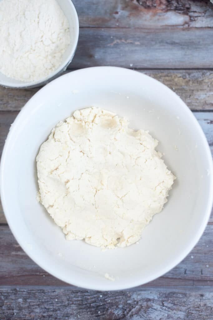 corn flour and butter in a white mixing bowl on a wooden background