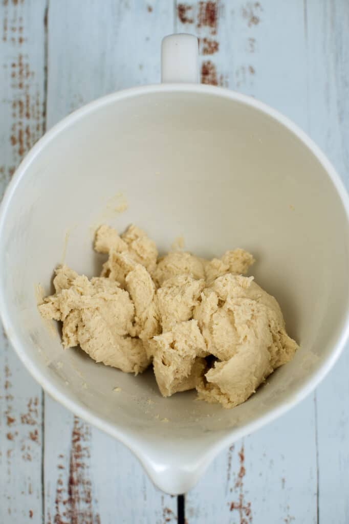 sourdough dough in a white mixing bowl on a wooden background