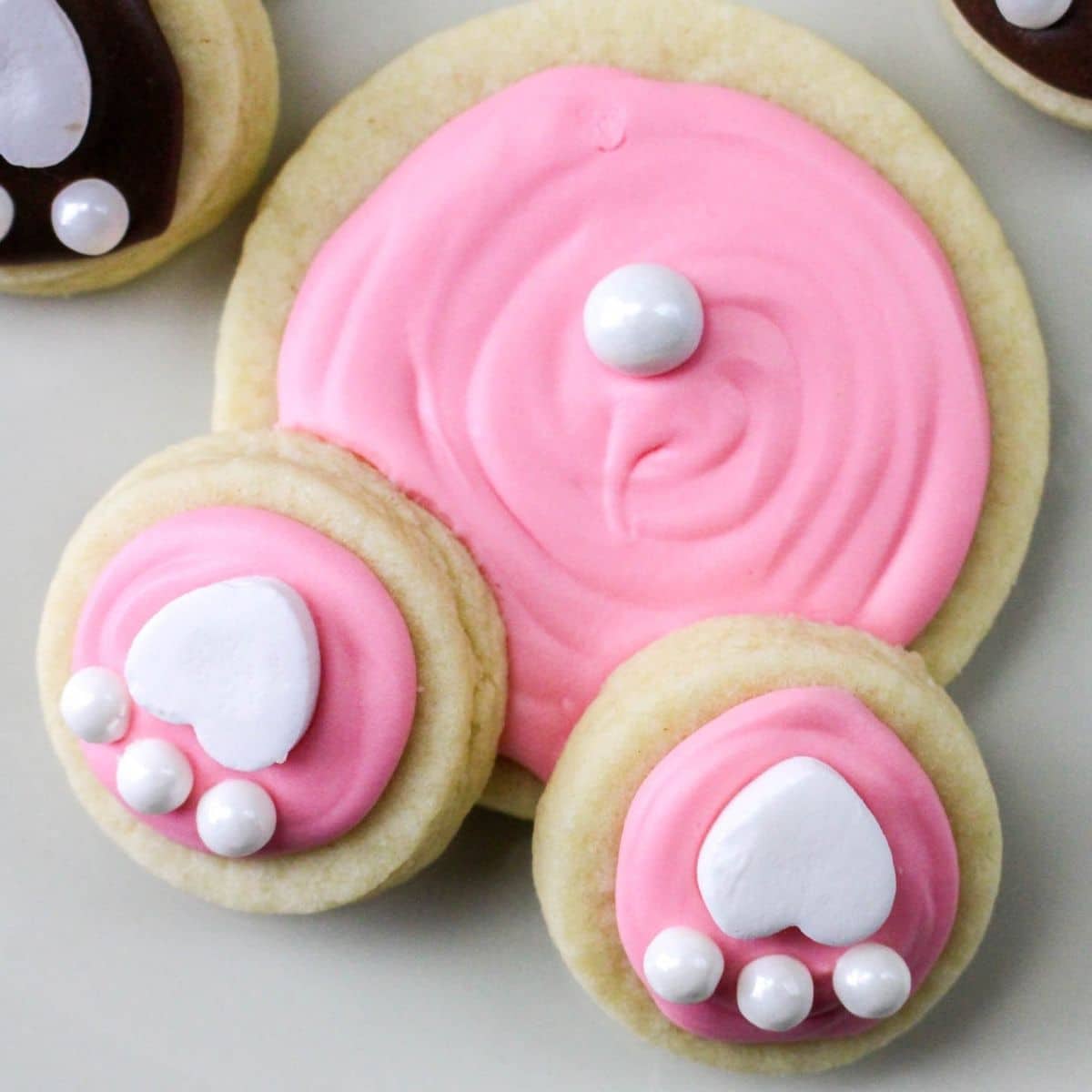 close up of a pink bunny butt cookies on a white plate
