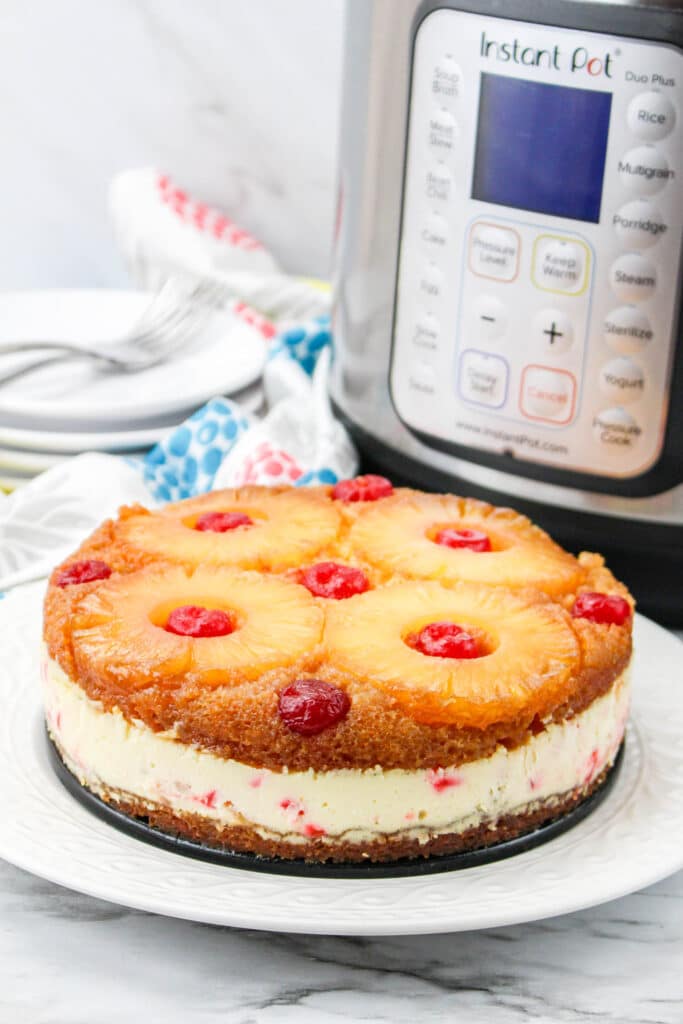 Pineapple Upside Down Cheesecake on a white plate with an Instant Pot in the background