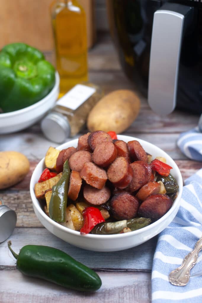 white bowl filled with air fryer kielbasa and vegetables