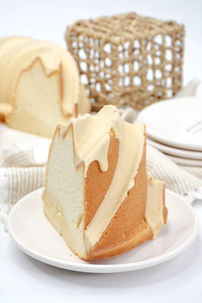 Side angel view of a slice of tres leches bundt cake on a white plate