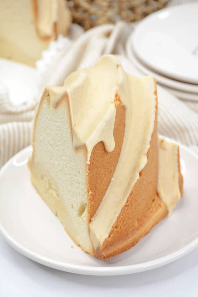 close up image of a slice of tres leches bundt cake on a white plate