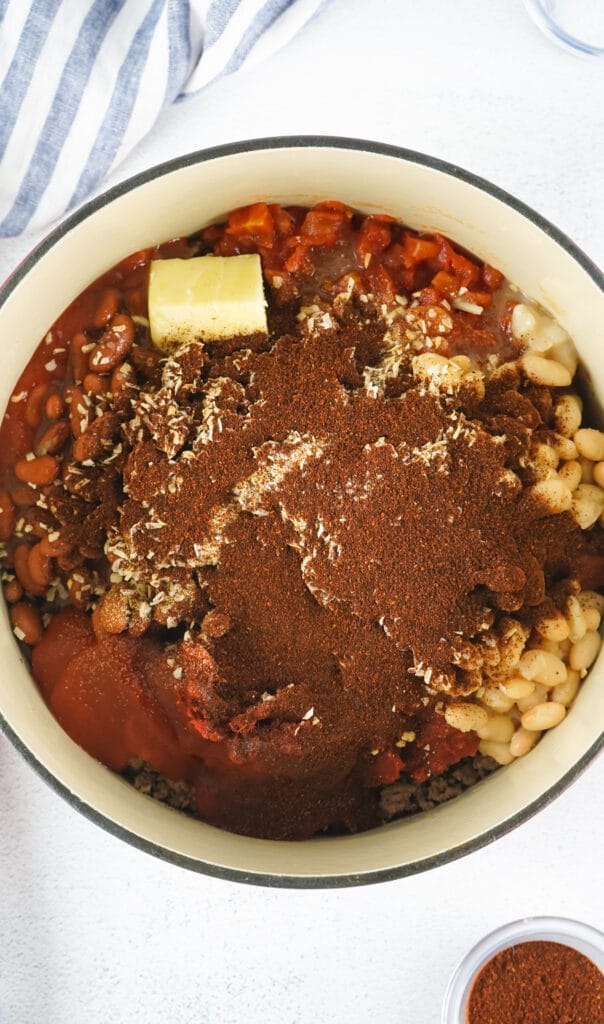 chili ingredients in a dutch oven on a white backdrop