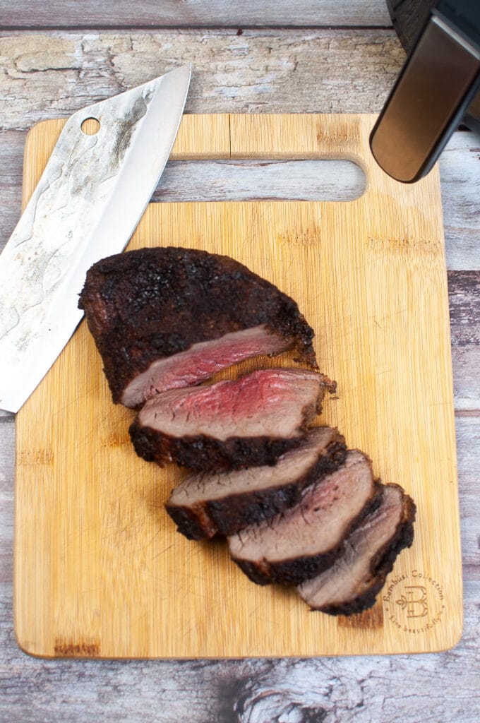 cooked tri tip on a wooden cutting board