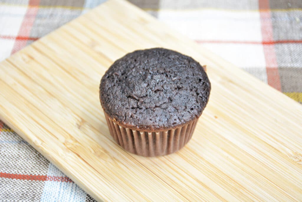 unfrosted chocolate cupcake on a wooden cutting board