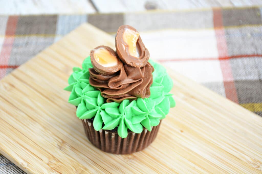 finished cadbury edg cupcake on a wooden cutting board