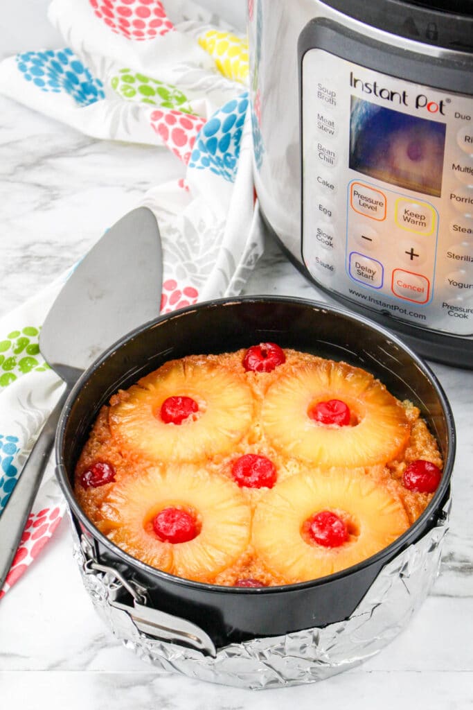 pineapple upside down cheesecake in a springform pan wrapped with foil