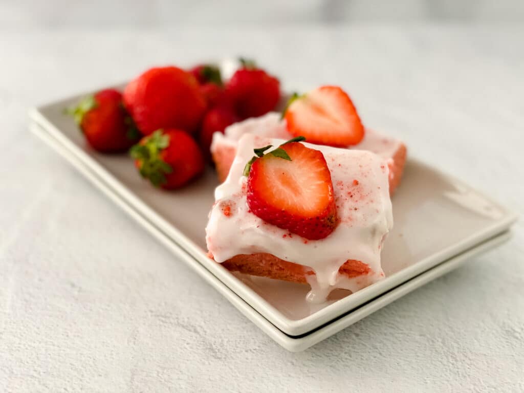 two strawberry blondies topped with slices of fresh strawberries