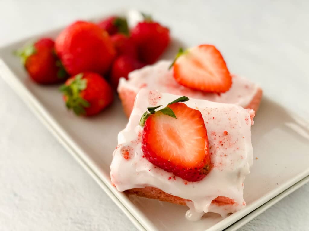 close up of two strawberry blondies on a white plate