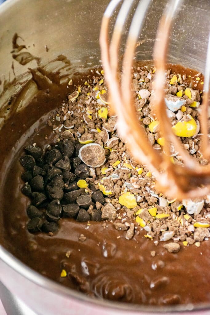 chocolate chips, mini eggs and brownie batter in a bowl