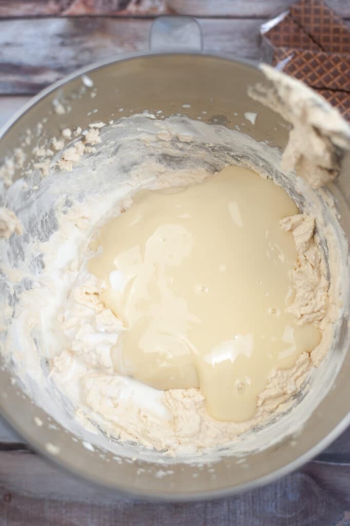 heavy cream being whipped in a stainless steel mixing bowl