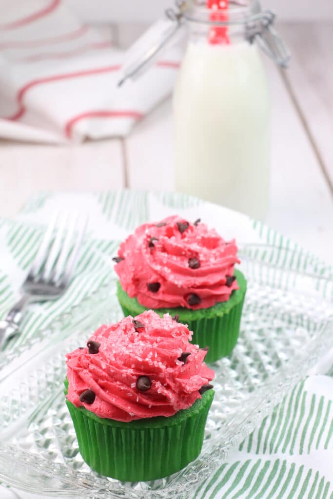close up of two watermelon cupcakes on a glass tray