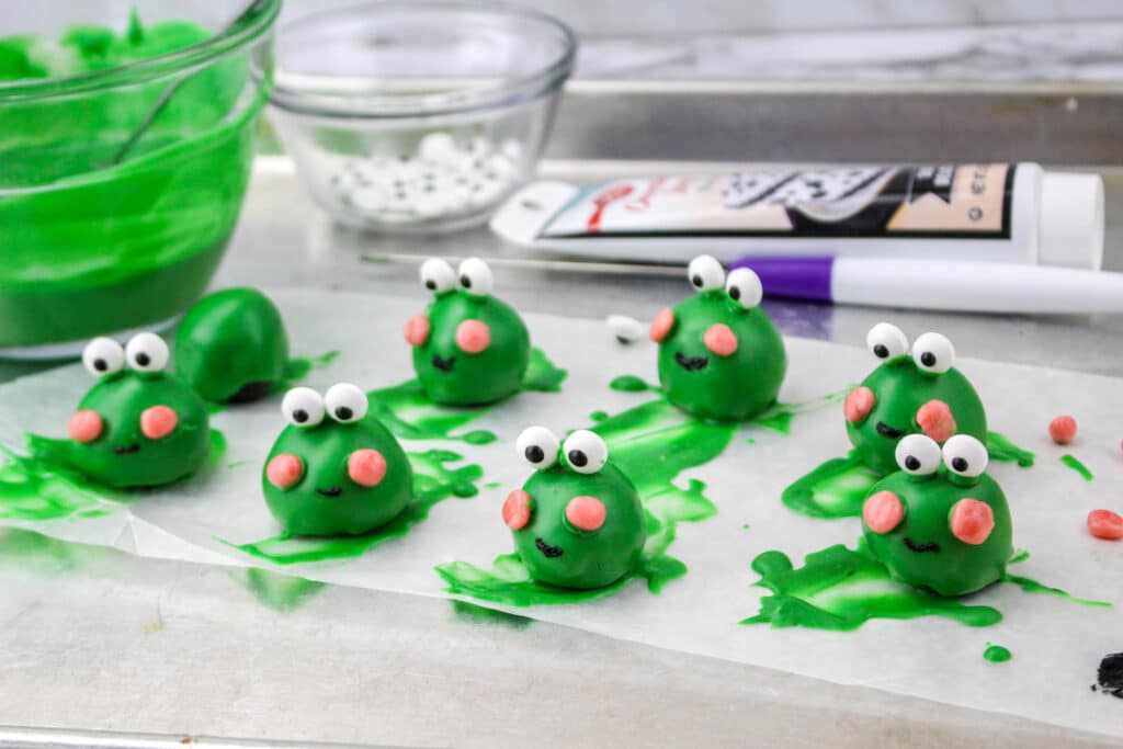 finished frog oreo balls drying on a parchment paper