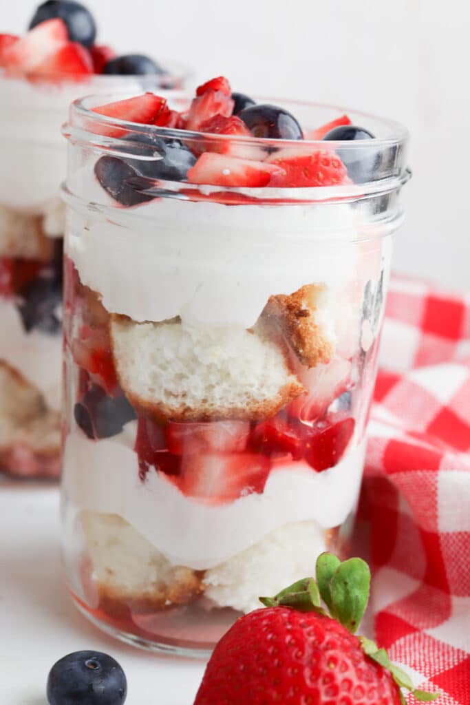 Close up of a jar of summer berry trifle in a mason jar