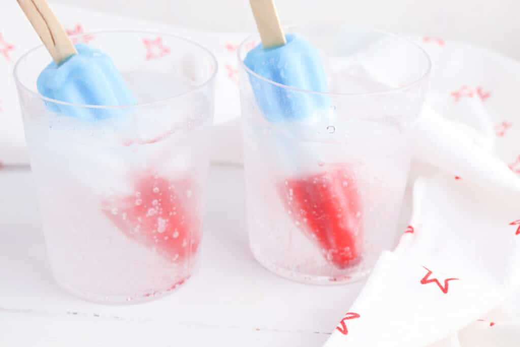 Bomb Pops added two glasses on a white backgroudn