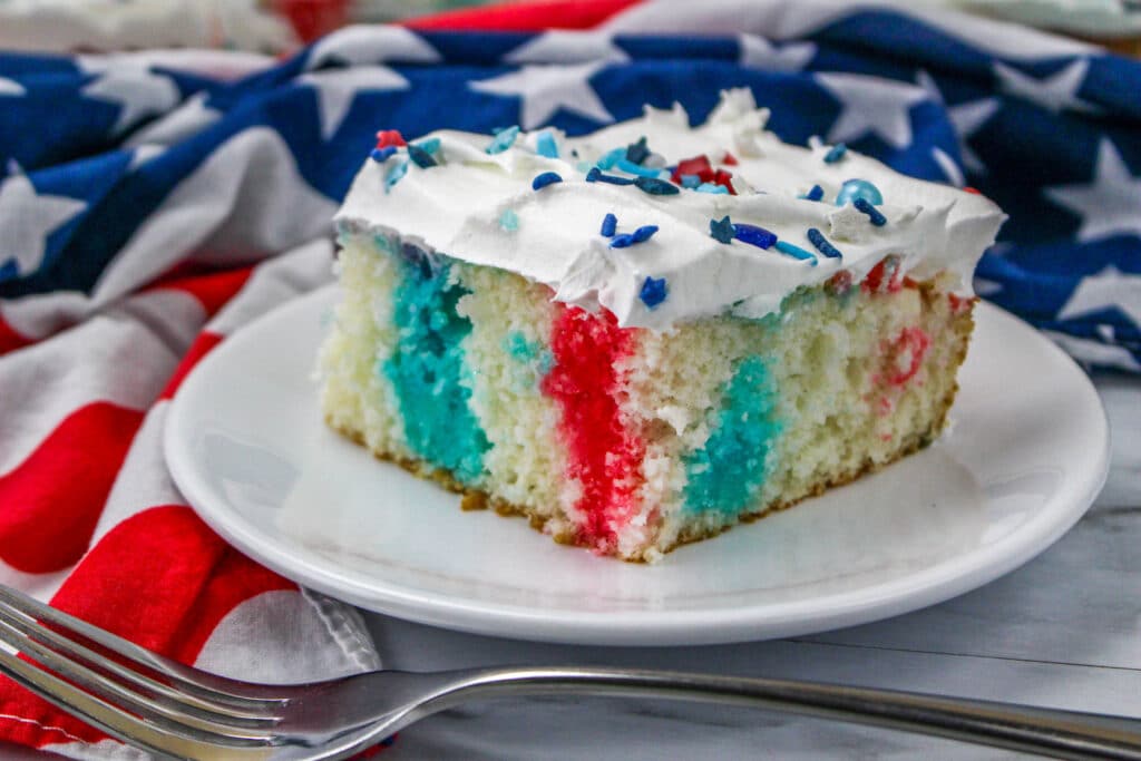 Close up a patriotic poke cake on a white plate