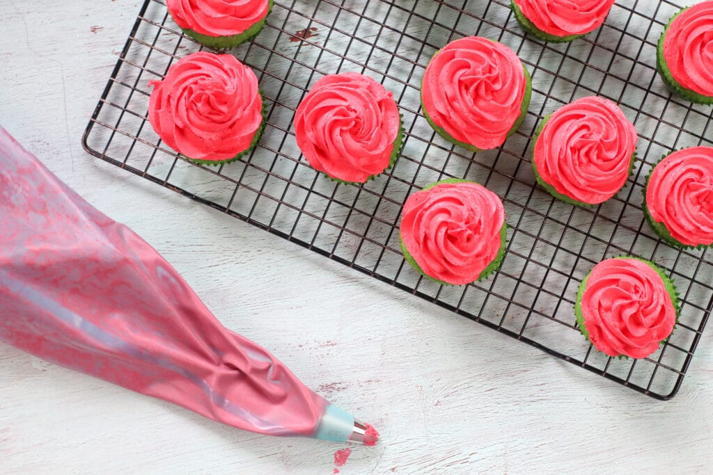 frosted watermelon cupcakes on a wire rack