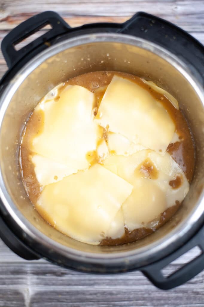 cheese on top of chicken breasts in a pressure cooker