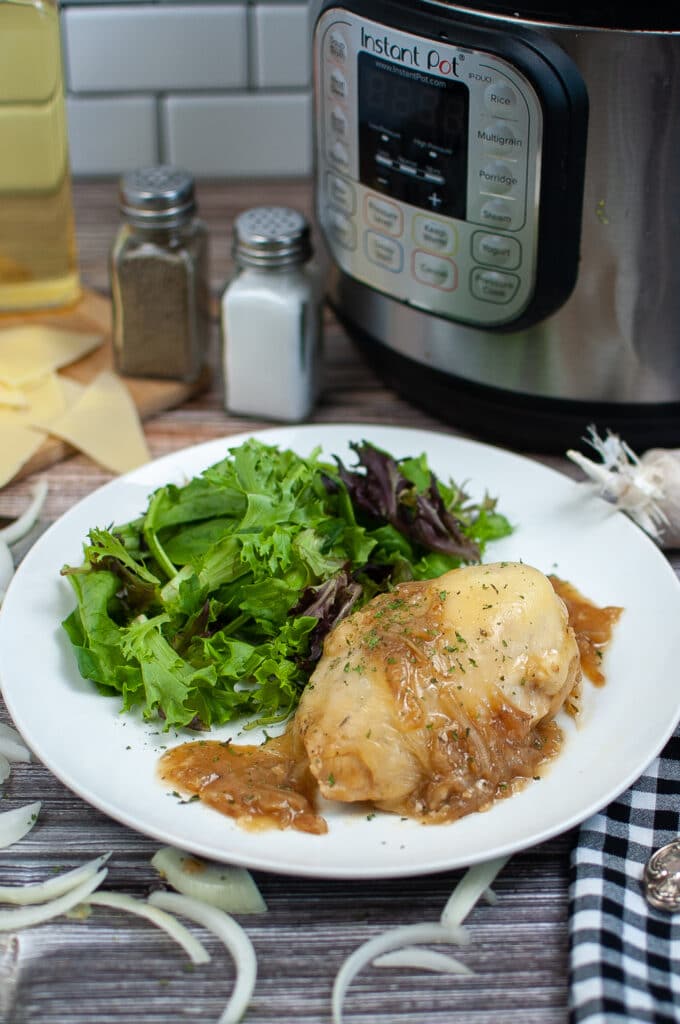Instant Pot French Onion Chicken on a white plate with a side salad