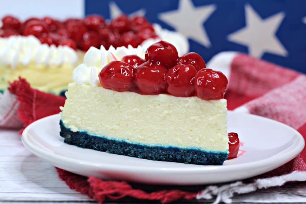 close up of a slice of patriotic cheesecake on a white plate